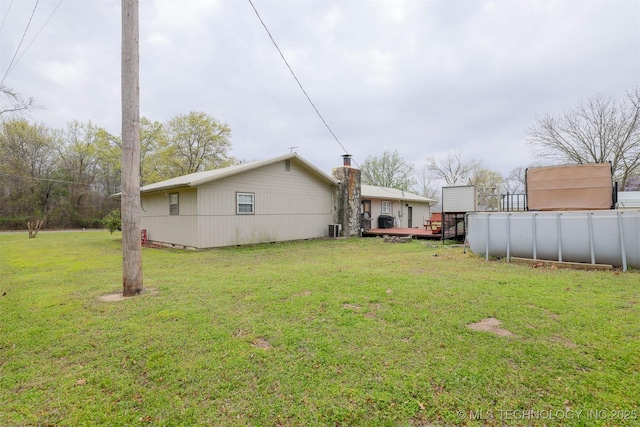view of yard with fence, a wooden deck, and cooling unit