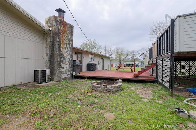 view of yard featuring a fire pit, central air condition unit, and a deck