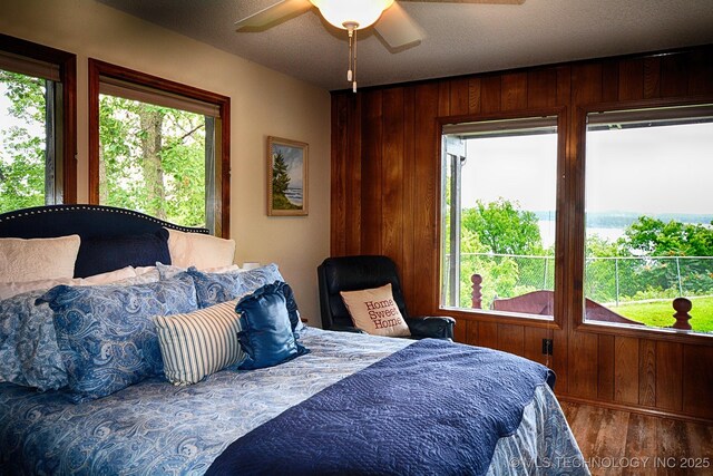 95884 Rock Cliff Rd, Gore, OK 74435 - bedroom with wooden walls, a ceiling fan, and wood finished floors