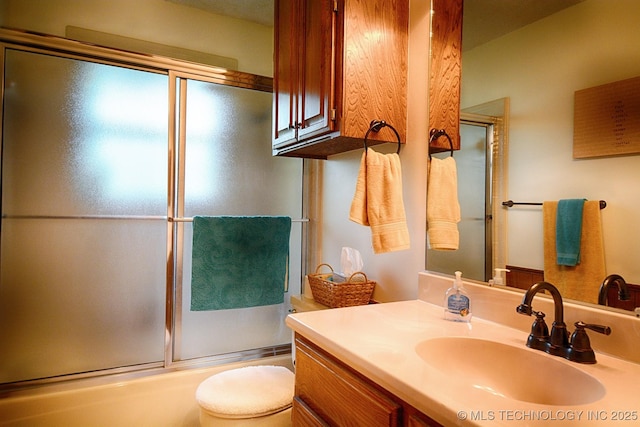 bathroom featuring vanity, enclosed tub / shower combo, and toilet