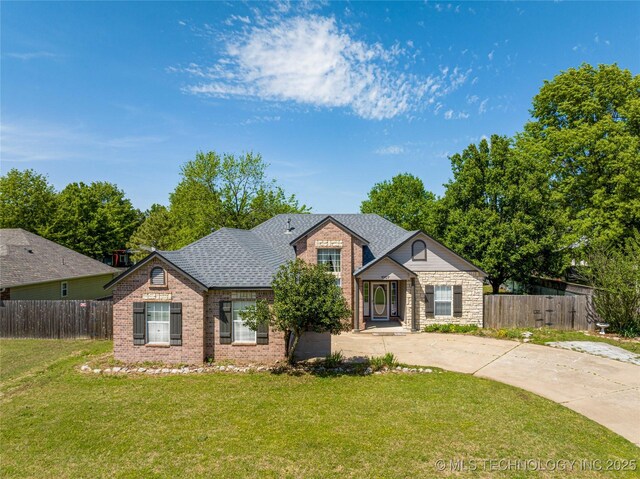 1007 W Beech St, Skiatook, OK 74070 - view of front facade with brick siding, a front lawn, fence, and driveway