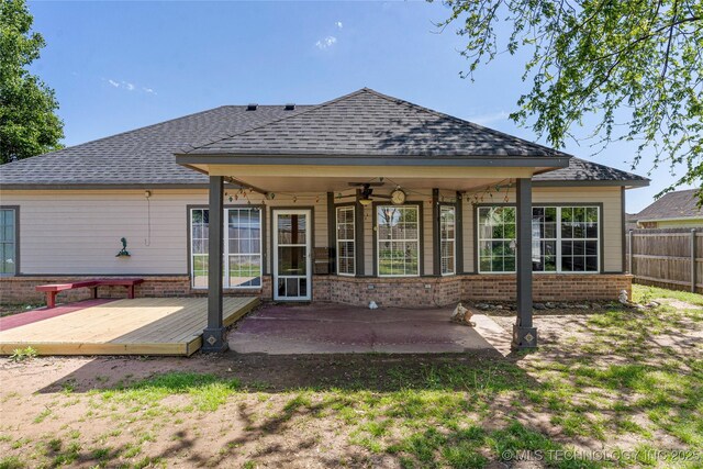 1007 W Beech St, Skiatook, OK 74070 - rear view of property featuring fence, a wooden deck, brick siding, a ceiling fan, and a patio area