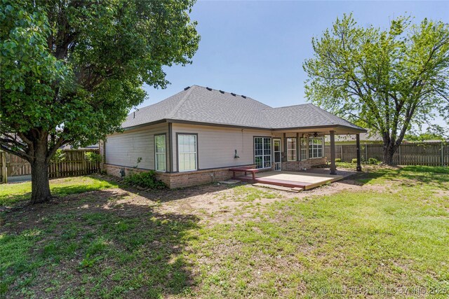 1007 W Beech St, Skiatook, OK 74070 - back of house with brick siding, a fenced backyard, roof with shingles, and a yard