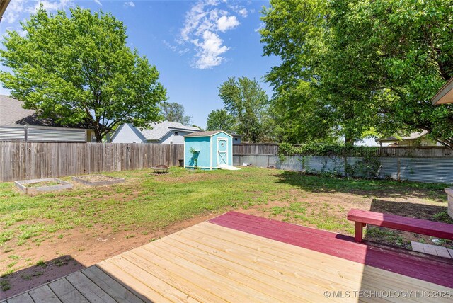 1007 W Beech St, Skiatook, OK 74070 - wooden terrace with a garden, a fenced backyard, a lawn, a storage shed, and an outbuilding