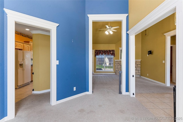 exterior space with baseboards, light colored carpet, and white fridge with ice dispenser