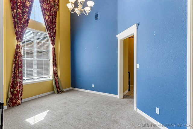 1007 W Beech St, Skiatook, OK 74070 - spare room with carpet flooring, baseboards, an inviting chandelier, and visible vents