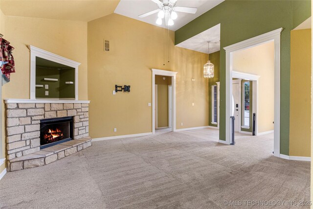 1007 W Beech St, Skiatook, OK 74070 - unfurnished living room featuring a ceiling fan, a stone fireplace, baseboards, high vaulted ceiling, and carpet flooring