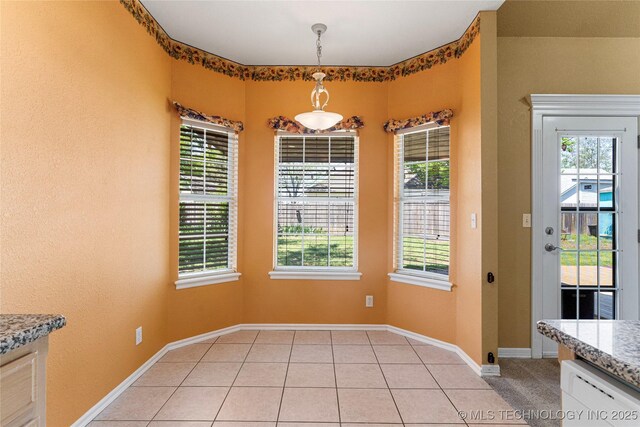 1007 W Beech St, Skiatook, OK 74070 - unfurnished dining area with plenty of natural light, baseboards, and light tile patterned flooring