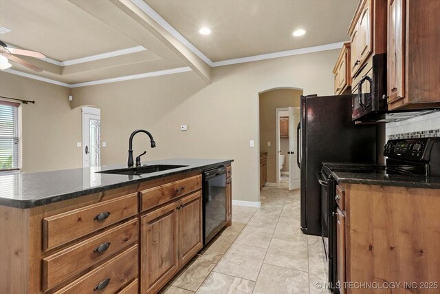 kitchen with ceiling fan, a kitchen island with sink, arched walkways, a sink, and black appliances