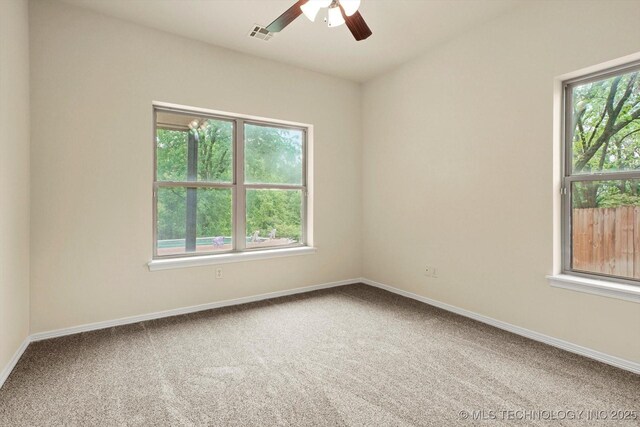 carpeted empty room featuring baseboards, a ceiling fan, and visible vents