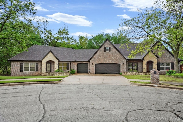 view of front of property with a shingled roof, an attached garage, driveway, and brick siding