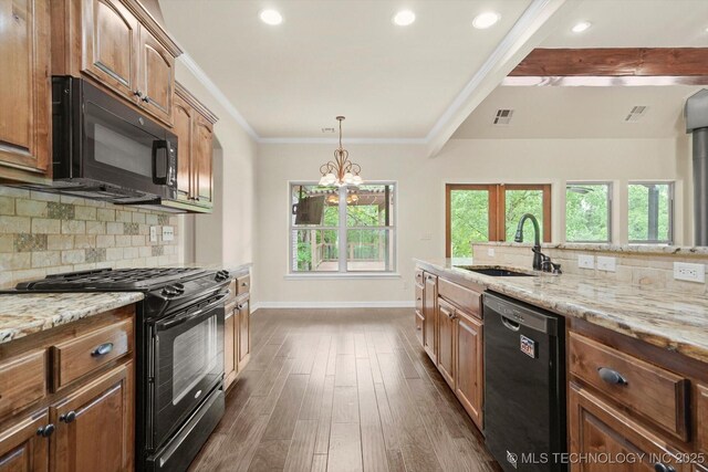 kitchen featuring a sink, light stone counters, backsplash, and black appliances