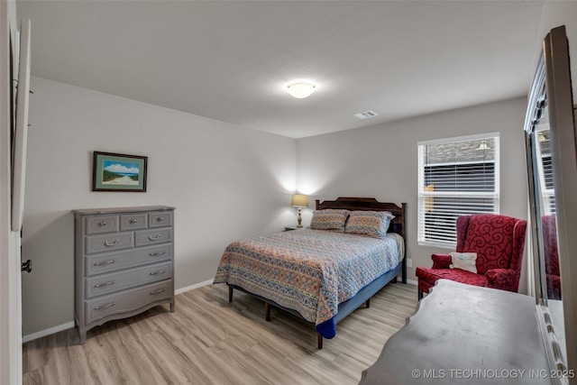 bedroom with light wood-style floors, baseboards, and visible vents