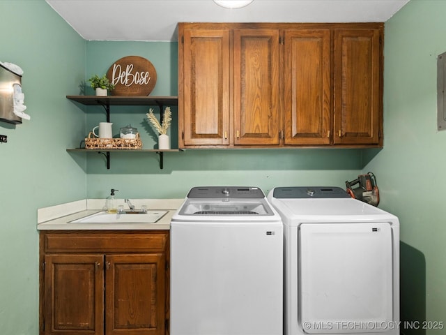 clothes washing area with cabinet space, separate washer and dryer, and a sink