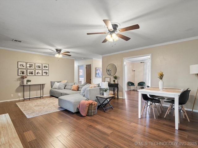 living room with crown molding, ceiling fan, baseboards, wood finished floors, and visible vents