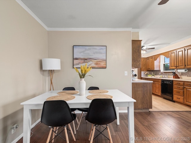 dining area featuring light wood-type flooring, ornamental molding, and ceiling fan