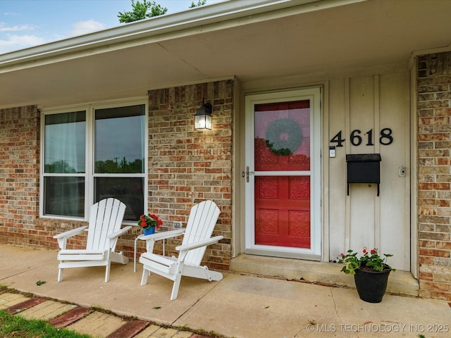 view of exterior entry with brick siding and board and batten siding