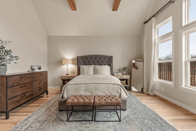 bedroom with light wood-type flooring, baseboards, and beam ceiling