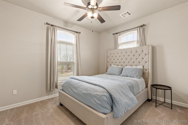 carpeted bedroom with visible vents, baseboards, and ceiling fan