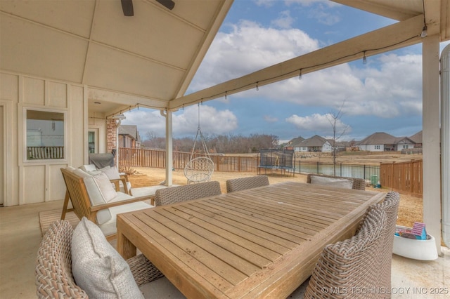 view of patio with a fenced backyard, outdoor dining space, and a trampoline