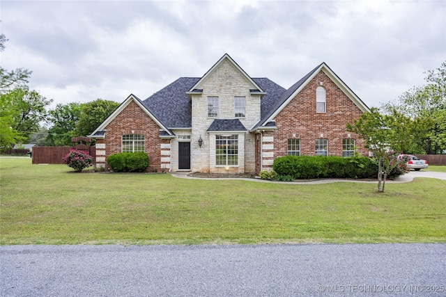 view of front of property with brick siding, a front lawn, and roof with shingles