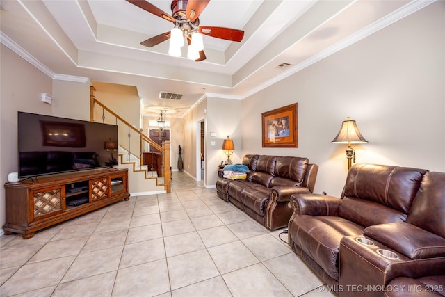 living room with stairway, a tray ceiling, and visible vents