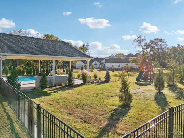view of yard featuring a gazebo, fence, playground community, and a fenced in pool