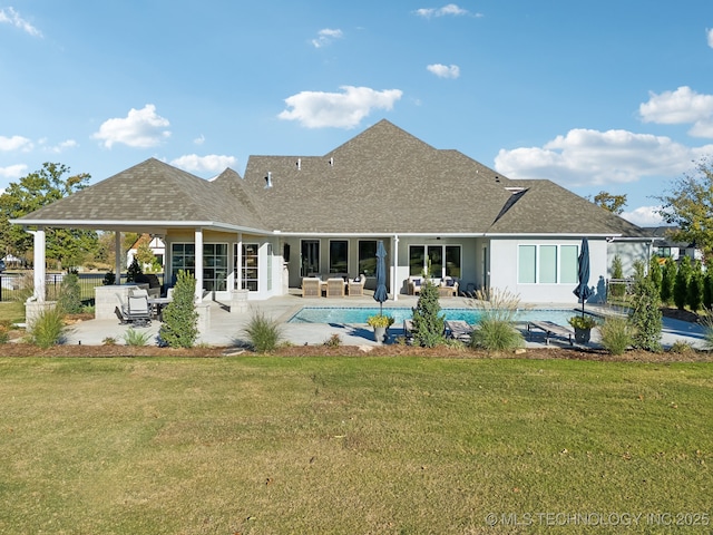 back of house with outdoor lounge area, roof with shingles, a yard, and a carport