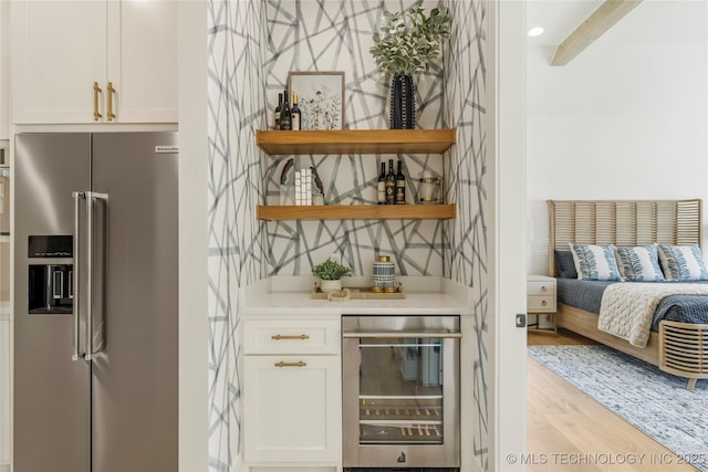 bar with wine cooler, a dry bar, light wood-type flooring, and high end fridge