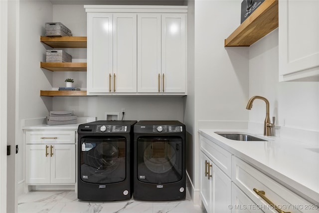 washroom featuring a sink, cabinet space, marble finish floor, and washer and clothes dryer