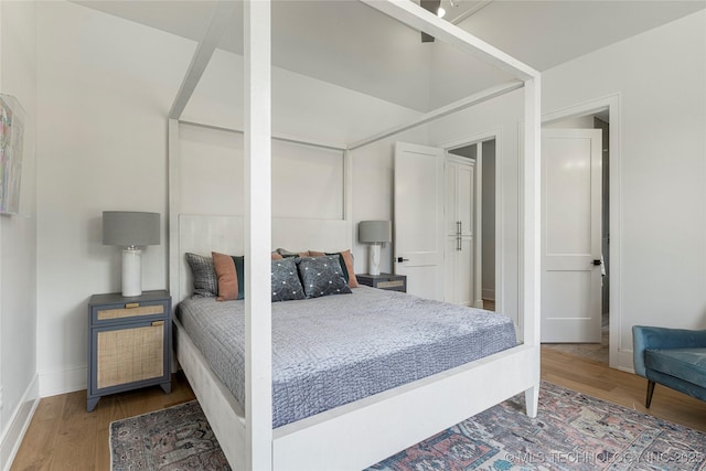 bedroom featuring baseboards and wood finished floors