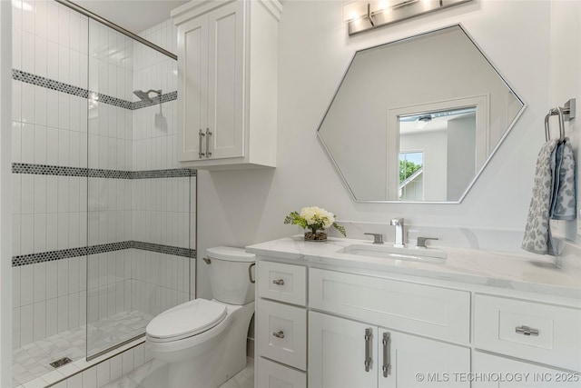 bathroom with vanity, a stall shower, and toilet