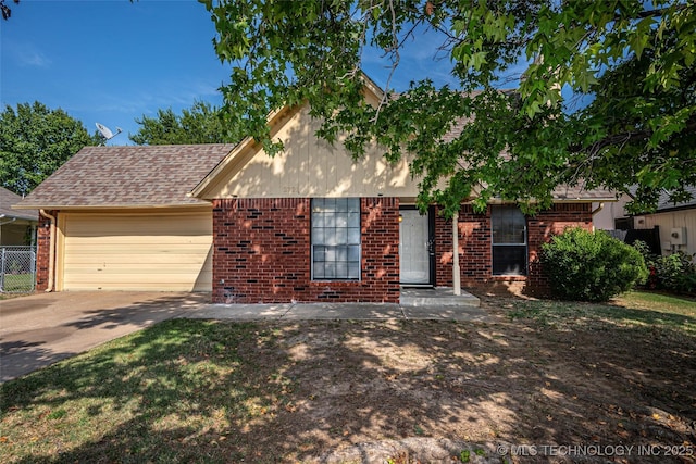 view of front of property with brick siding, an attached garage, driveway, and fence