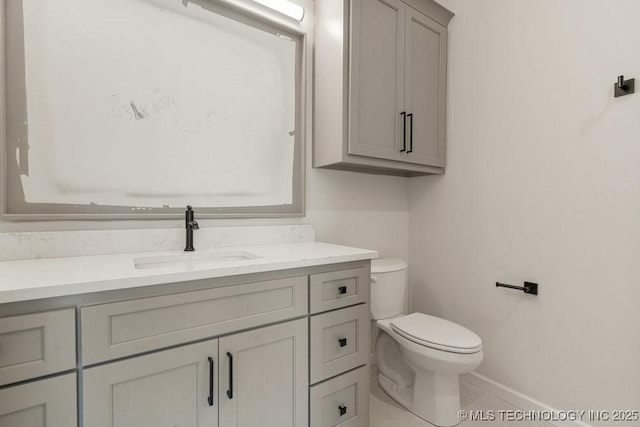 bathroom featuring toilet, baseboards, tile patterned flooring, and vanity