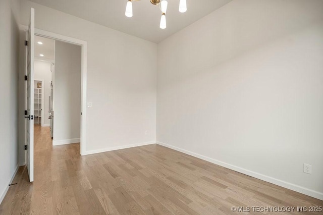 spare room featuring baseboards and light wood-style flooring