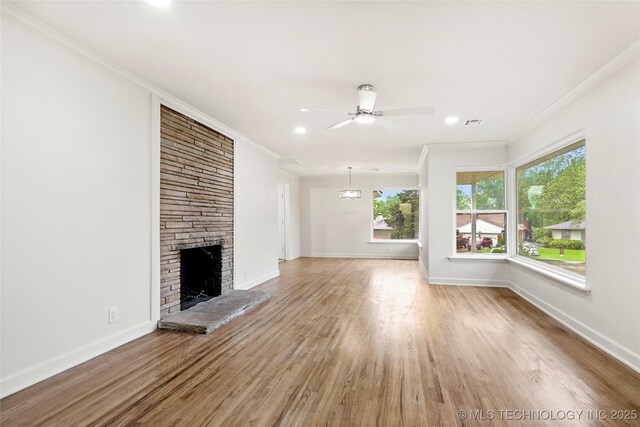 4814 E 37th St, Tulsa, OK 74135 - unfurnished living room featuring crown molding, ceiling fan, a large fireplace, baseboards, and light wood-type flooring