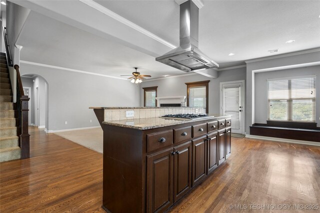 9502 S 73rd E Ave, Tulsa, OK 74133 - kitchen with a ceiling fan, island range hood, crown molding, arched walkways, and wood finished floors