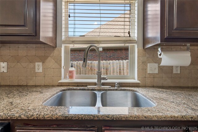 9502 S 73rd E Ave, Tulsa, OK 74133 - kitchen featuring light stone counters, a sink, backsplash, and dark brown cabinetry