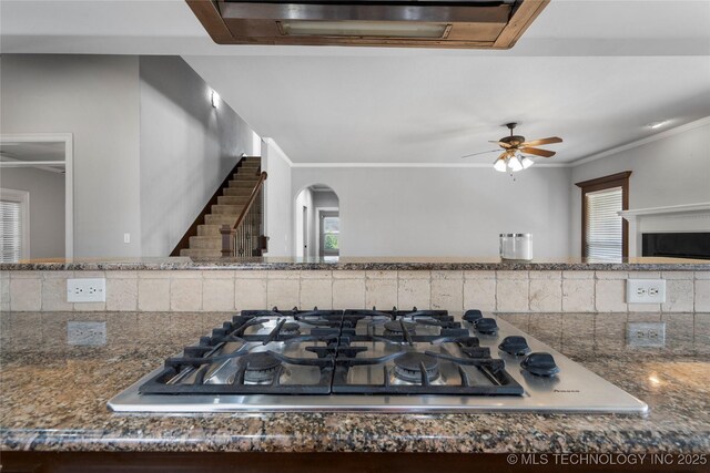 9502 S 73rd E Ave, Tulsa, OK 74133 - room details featuring ornamental molding, stainless steel gas cooktop, arched walkways, a ceiling fan, and dark stone countertops
