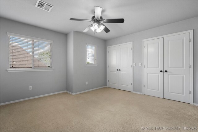 9502 S 73rd E Ave, Tulsa, OK 74133 - unfurnished bedroom with visible vents, two closets, light carpet, baseboards, and ceiling fan