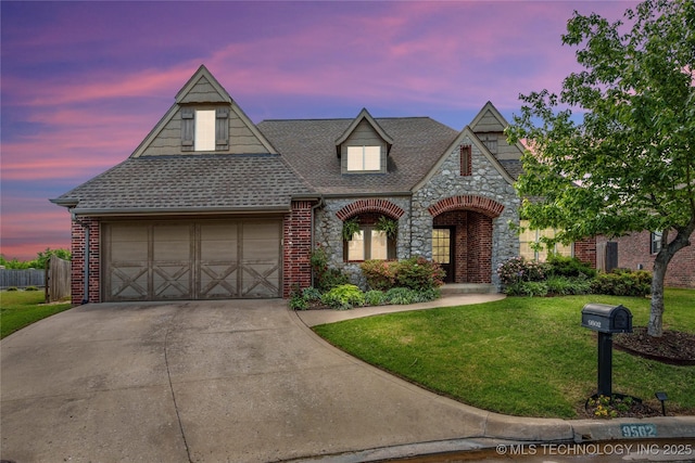 9502 S 73rd E Ave, Tulsa, OK 74133 - view of front of home featuring roof with shingles, stone siding, a garage, concrete driveway, and a yard