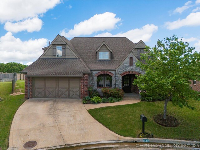 9502 S 73rd E Ave, Tulsa, OK 74133 - view of front facade featuring stone siding, concrete driveway, brick siding, and a front yard