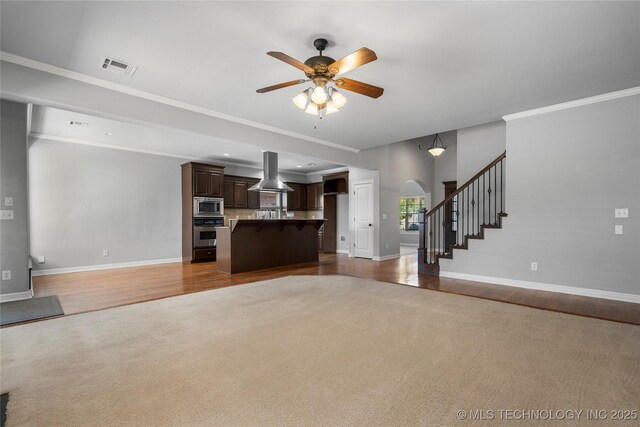 9502 S 73rd E Ave, Tulsa, OK 74133 - unfurnished living room with arched walkways, ceiling fan, baseboards, and carpet