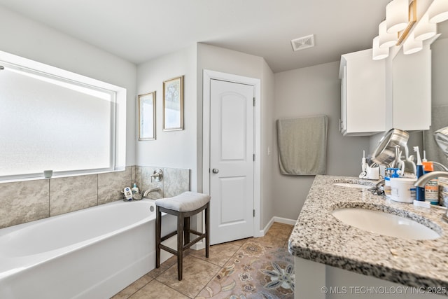 full bath featuring a sink, double vanity, tile patterned floors, visible vents, and a bath