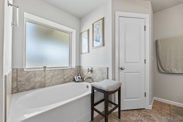 full bath with baseboards, tile patterned flooring, and a garden tub