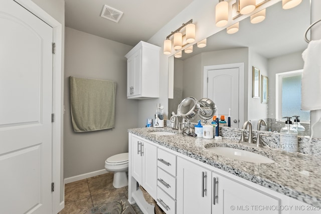 full bath featuring visible vents, a sink, double vanity, and toilet