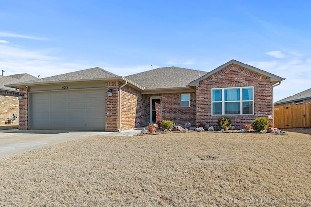 single story home featuring roof with shingles, fence, brick siding, a garage, and concrete driveway