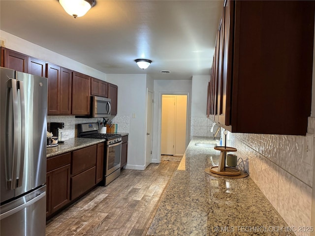 116 S Camden St, Muskogee, OK 74403 - kitchen with stainless steel appliances, a sink, backsplash, and light stone countertops