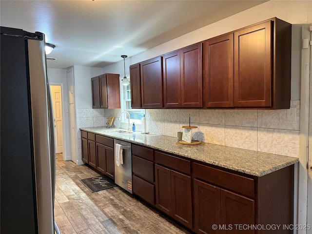 116 S Camden St, Muskogee, OK 74403 - kitchen with appliances with stainless steel finishes, a sink, decorative backsplash, hanging light fixtures, and light stone countertops