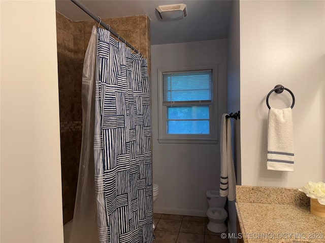 bathroom featuring a shower with shower curtain, tile patterned floors, and toilet